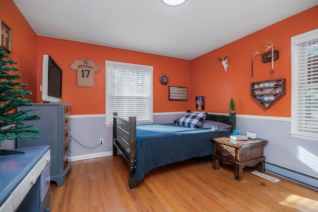 6191 Baxter Rd, Baxter, TN 38544 - bedroom featuring light wood finished floors, multiple windows, and a baseboard radiator