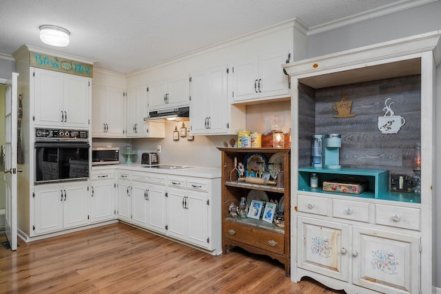 6191 Baxter Rd, Baxter, TN 38544 - kitchen with black appliances, ornamental molding, under cabinet range hood, white cabinets, and light wood-type flooring