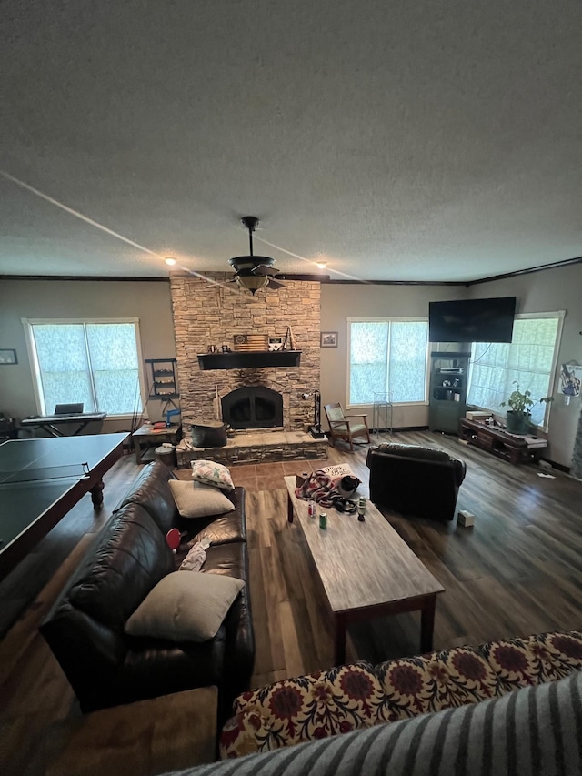 6191 Baxter Rd, Baxter, TN 38544 - living area with wood finished floors, a textured ceiling, a stone fireplace, and a ceiling fan