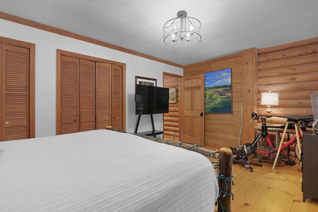 1261 S Cedar Ln, Chickamauga, GA 30707 - bedroom with light wood-type flooring, a chandelier, rustic walls, and two closets