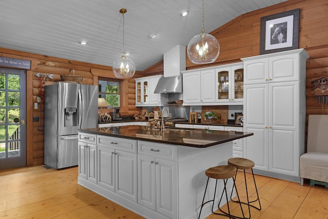 1261 S Cedar Ln, Chickamauga, GA 30707 - kitchen with stainless steel refrigerator with ice dispenser, log walls, vaulted ceiling, dark countertops, and wall chimney exhaust hood