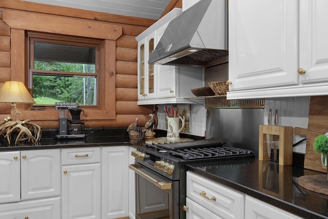 1261 S Cedar Ln, Chickamauga, GA 30707 - kitchen with gas range, wall chimney exhaust hood, rustic walls, dark countertops, and glass insert cabinets