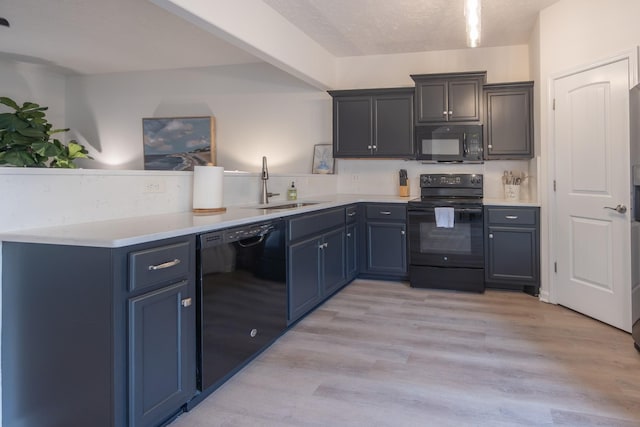5314 Dan Post Way, Murfreesboro, TN 37128 - kitchen featuring black appliances, a peninsula, light countertops, light wood-style flooring, and blue cabinetry