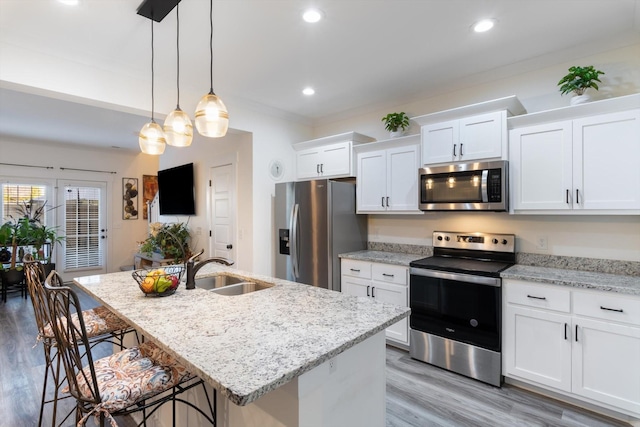 3331 Alta Ln, Murfreesboro, TN 37128 - kitchen with appliances with stainless steel finishes, a breakfast bar area, light wood-style floors, a center island with sink, and white cabinetry