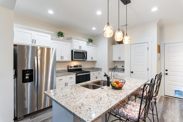 3331 Alta Ln, Murfreesboro, TN 37128 - kitchen with appliances with stainless steel finishes, wood finished floors, a breakfast bar, a kitchen island with sink, and ornamental molding