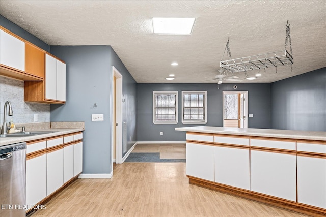 708 Poston Dr, Monterey, TN 38574 - kitchen with dishwasher, white cabinetry, light wood finished floors, light countertops, and backsplash