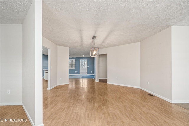 708 Poston Dr, Monterey, TN 38574 - unfurnished living room with light wood-style floors and a textured ceiling