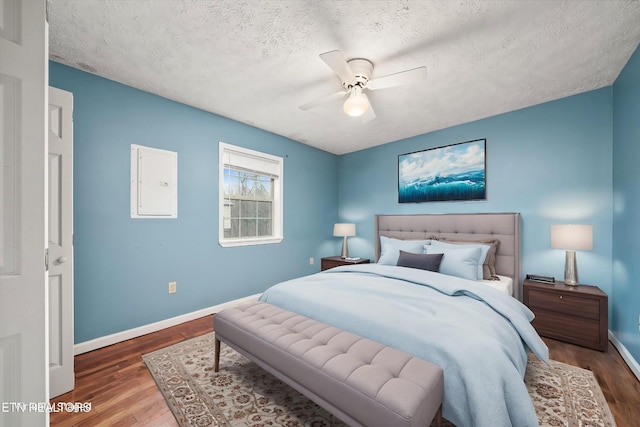 708 Poston Dr, Monterey, TN 38574 - bedroom with wood finished floors, electric panel, a textured ceiling, and a ceiling fan