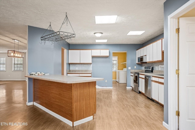 708 Poston Dr, Monterey, TN 38574 - kitchen with appliances with stainless steel finishes, light countertops, light wood finished floors, white cabinetry, and a textured ceiling