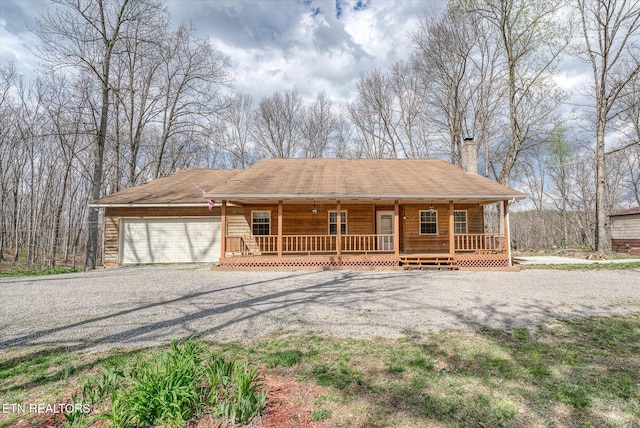 708 Poston Dr, Monterey, TN 38574 - view of front of house with a porch, gravel driveway, a chimney, and an attached garage