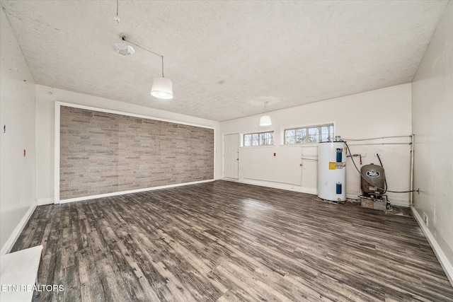 708 Poston Dr, Monterey, TN 38574 - unfurnished living room with electric water heater, a textured ceiling, brick wall, and wood finished floors