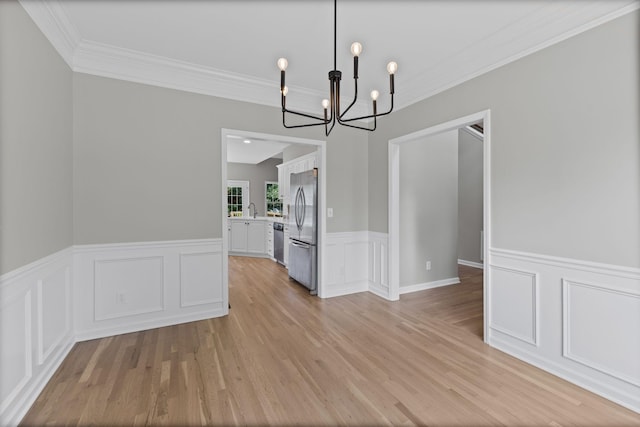 236 Comer Cir, Murfreesboro, TN 37128 - unfurnished dining area featuring a chandelier, crown molding, light wood-style floors, a wainscoted wall, and a decorative wall