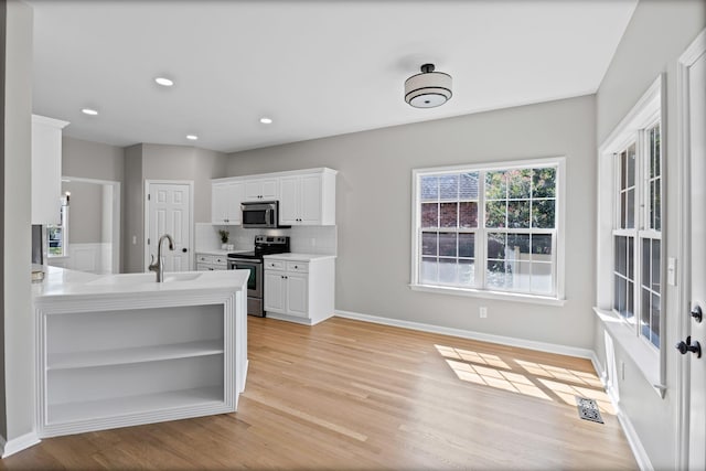 236 Comer Cir, Murfreesboro, TN 37128 - kitchen with appliances with stainless steel finishes, open shelves, light countertops, white cabinetry, and light wood finished floors