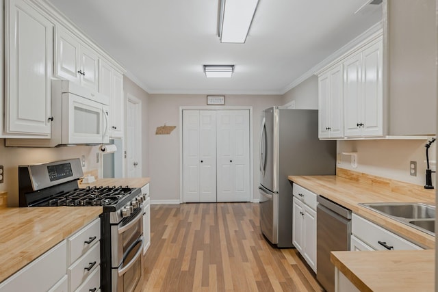 2117 Spring Hill Cir, Spring Hill, TN 37174 - kitchen with appliances with stainless steel finishes, butcher block countertops, light wood-style flooring, white cabinetry, and crown molding