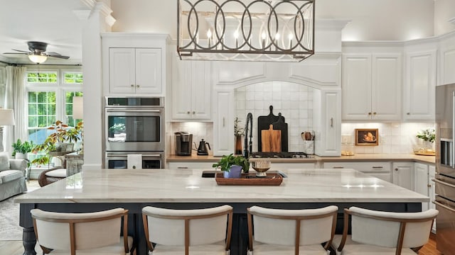 529 Derby Downs, Lebanon, TN 37087 - kitchen with white cabinets, tasteful backsplash, a center island, and stainless steel appliances