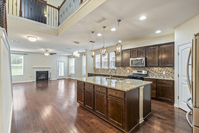 654 Foster Ln, Mount Juliet, TN 37122 - kitchen featuring appliances with stainless steel finishes, a ceiling fan, dark brown cabinets, an island with sink, and dark wood-style flooring
