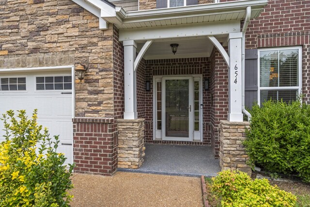 654 Foster Ln, Mount Juliet, TN 37122 - entrance to property with brick siding, stone siding, a garage, and covered porch