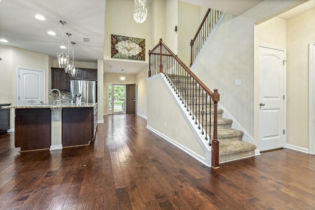 654 Foster Ln, Mount Juliet, TN 37122 - kitchen featuring a chandelier, dark wood finished floors, dark brown cabinets, light stone countertops, and a center island with sink