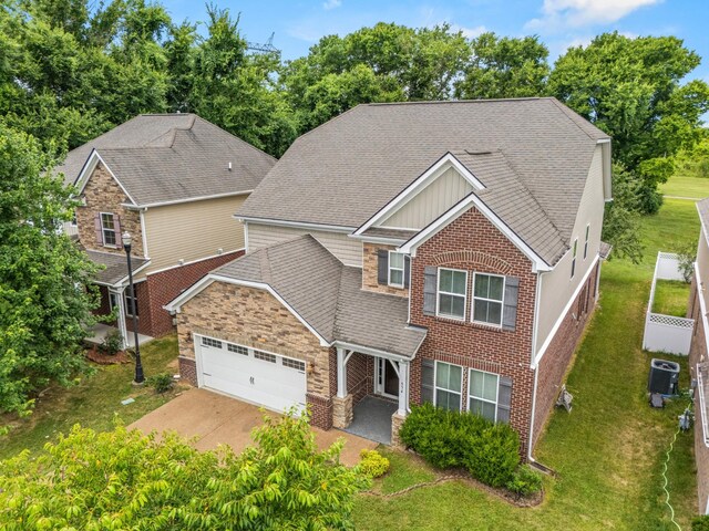 654 Foster Ln, Mount Juliet, TN 37122 - view of front of home featuring an attached garage, a shingled roof, a front lawn, and stone siding