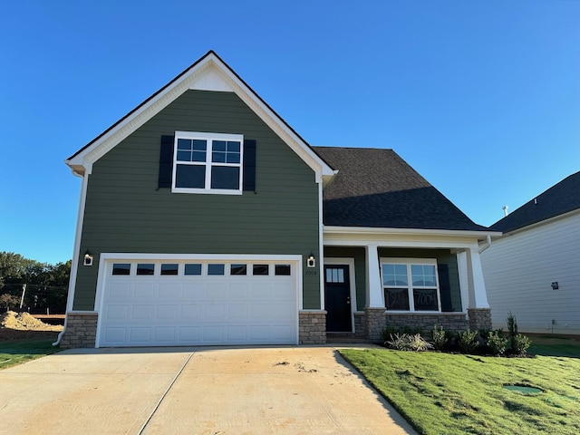 9013 Ada Way, Fairview, TN 37062 - craftsman-style home with stone siding, a garage, concrete driveway, a front yard, and roof with shingles