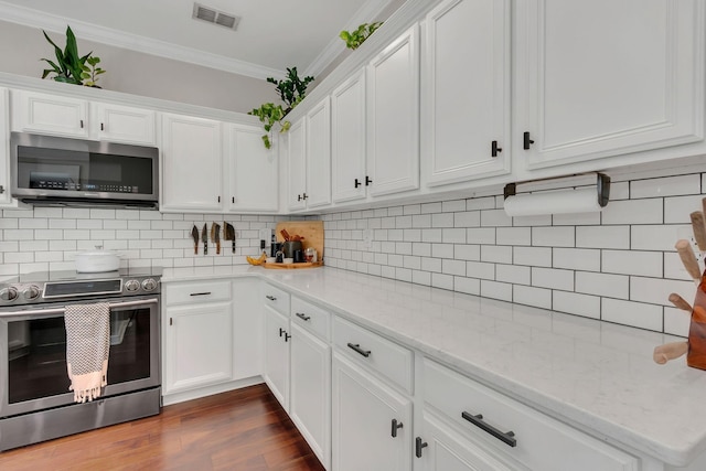 1016 Nealcrest Cir, Spring Hill, TN 37174 - kitchen with stainless steel appliances, crown molding, white cabinetry, tasteful backsplash, and dark wood-type flooring