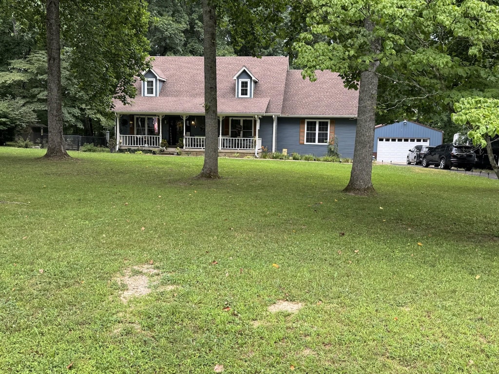 625 Mag A Mor Dr, Lafayette, TN 37083 - cape cod-style house featuring covered porch, a front yard, a garage, and an outbuilding