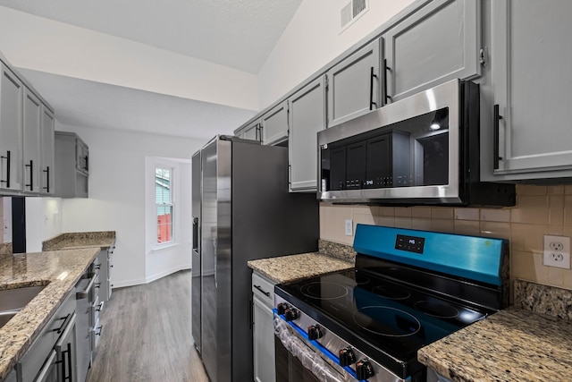 1300 Cadogan Way, Antioch, TN 37013 - kitchen featuring stainless steel appliances, light wood finished floors, gray cabinets, and tasteful backsplash
