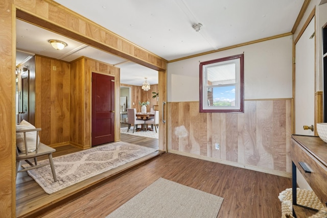 2274 Indian Mound Rd, Woodlawn, TN 37191 - foyer entrance featuring wood walls, wood finished floors, a chandelier, wainscoting, and ornamental molding