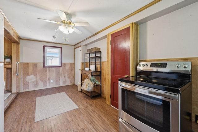 2274 Indian Mound Rd, Woodlawn, TN 37191 - kitchen featuring stainless steel range with electric stovetop, wainscoting, light wood-type flooring, ornamental molding, and a ceiling fan