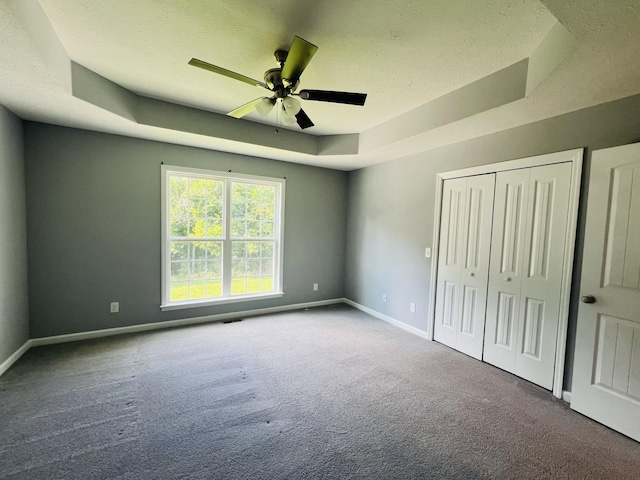 301 Union Hollow Rd, Petersburg, TN 37144 - unfurnished bedroom featuring carpet floors, a tray ceiling, a textured ceiling, a closet, and a ceiling fan