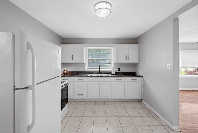 211 Navaho Trl, Hopkinsville, KY 42240 - kitchen featuring white appliances, dark countertops, healthy amount of natural light, and white cabinets