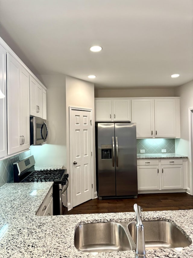 604 Douglas St, Lebanon, TN 37087 - kitchen with appliances with stainless steel finishes, white cabinetry, light stone counters, tasteful backsplash, and recessed lighting
