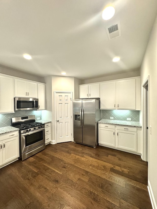 604 Douglas St, Lebanon, TN 37087 - kitchen featuring stainless steel appliances, tasteful backsplash, dark wood finished floors, white cabinets, and light stone countertops
