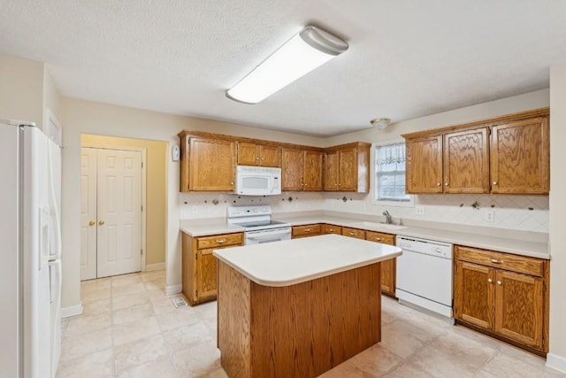1011 Shirley Dr, Lebanon, TN 37087 - kitchen featuring white appliances, light countertops, backsplash, brown cabinets, and a kitchen island