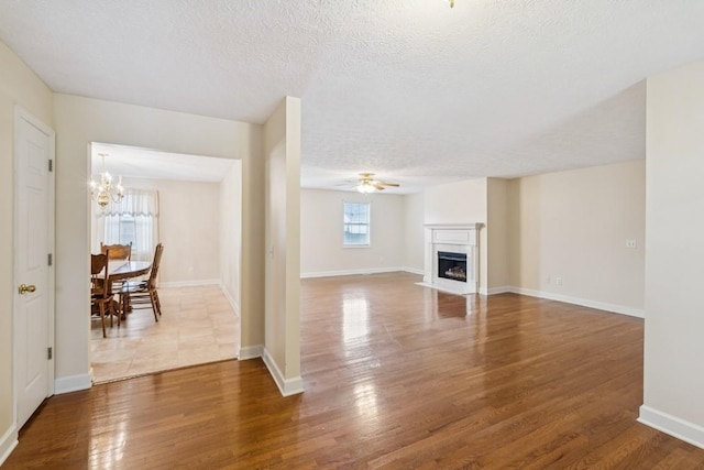 1011 Shirley Dr, Lebanon, TN 37087 - unfurnished living room with a ceiling fan, wood finished floors, a chandelier, a fireplace, and a textured ceiling
