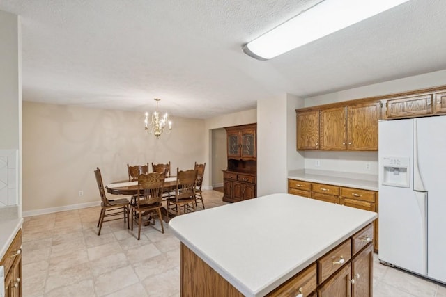 1011 Shirley Dr, Lebanon, TN 37087 - kitchen with white refrigerator with ice dispenser, brown cabinets, light countertops, pendant lighting, and a kitchen island