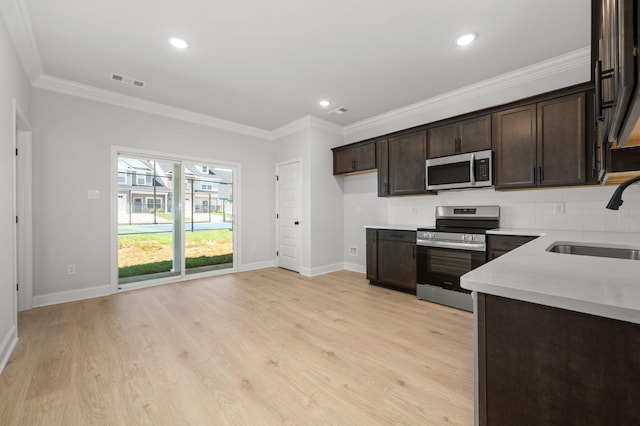 516 Rohan Dr, Murfreesboro, TN 37129 - kitchen with appliances with stainless steel finishes, dark brown cabinets, crown molding, light wood-type flooring, and decorative backsplash