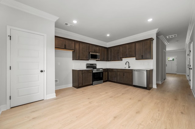 516 Rohan Dr, Murfreesboro, TN 37129 - kitchen with stainless steel appliances, dark brown cabinets, crown molding, light countertops, and light wood finished floors