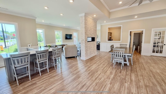 516 Rohan Dr, Murfreesboro, TN 37129 - dining room with crown molding, light wood-style floors, a wainscoted wall, a fireplace, and a decorative wall