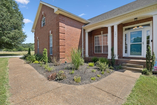 131 E Robertson Rd, Castalian Springs, TN 37031 - view of exterior entry featuring brick siding, a shingled roof, and covered porch