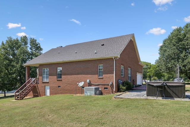 131 E Robertson Rd, Castalian Springs, TN 37031 - back of house featuring a garage, a hot tub, a yard, and brick siding
