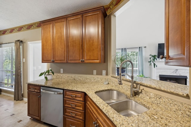 131 E Robertson Rd, Castalian Springs, TN 37031 - kitchen with dishwasher, light stone counters, a high end fireplace, brown cabinetry, and light tile patterned floors