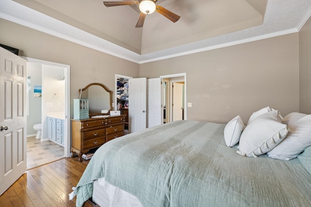 131 E Robertson Rd, Castalian Springs, TN 37031 - bedroom featuring a tray ceiling, wood-type flooring, a spacious closet, ensuite bath, and ornamental molding