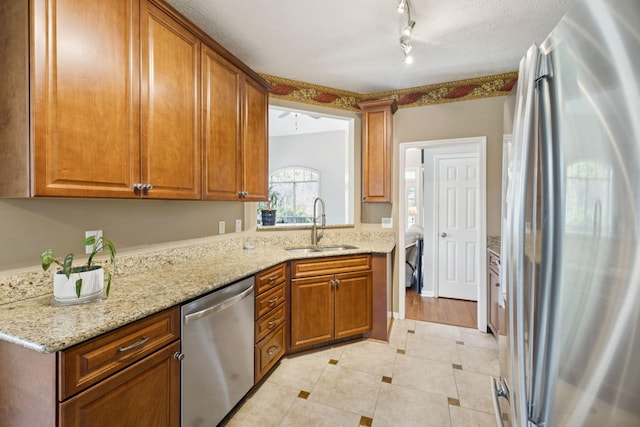 131 E Robertson Rd, Castalian Springs, TN 37031 - kitchen featuring stainless steel appliances, brown cabinets, light tile patterned flooring, rail lighting, and light stone counters