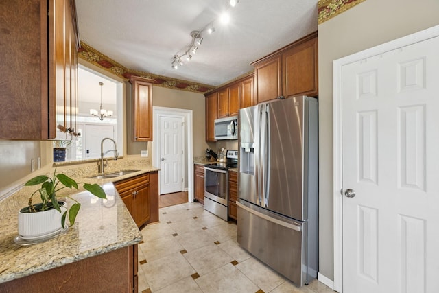 131 E Robertson Rd, Castalian Springs, TN 37031 - kitchen featuring stainless steel appliances, a chandelier, light stone counters, and brown cabinetry