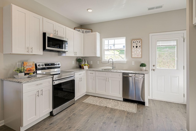 225 Tara Ct Unit 225, Columbia, TN 38401 - kitchen with appliances with stainless steel finishes, white cabinetry, light wood-style floors, light stone counters, and recessed lighting