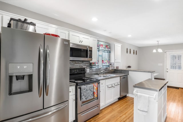 397 W Mcglothlin St, Portland, TN 37148 - kitchen with appliances with stainless steel finishes, white cabinets, light wood-style flooring, decorative backsplash, and a chandelier