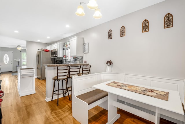 397 W Mcglothlin St, Portland, TN 37148 - dining area with light wood-style flooring, a chandelier, recessed lighting, a wainscoted wall, and a ceiling fan