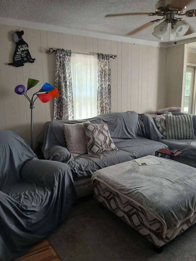 197 Stigall St, Camden, TN 38320 - living area with a textured ceiling, ceiling fan, and wood walls