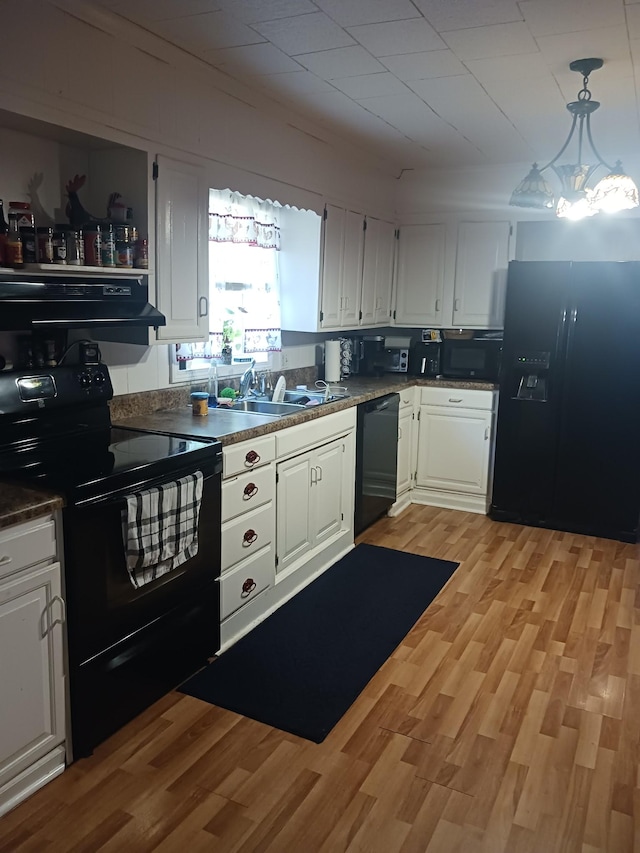 197 Stigall St, Camden, TN 38320 - kitchen featuring black appliances, range hood, white cabinets, light wood-type flooring, and dark countertops